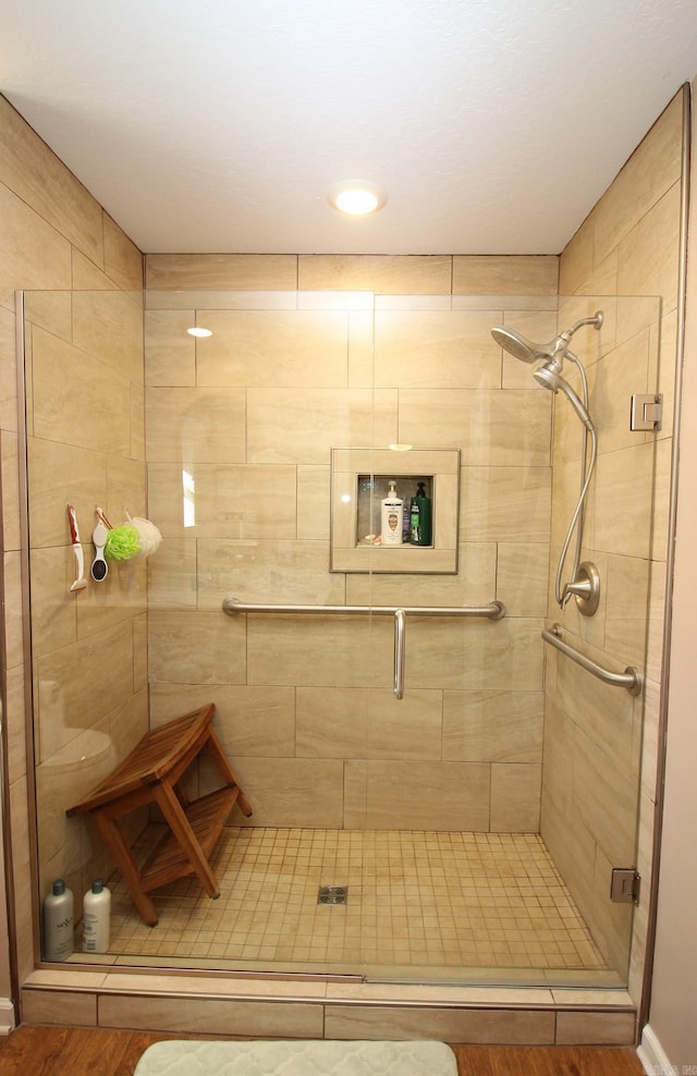 bathroom featuring a shower with shower door and wood-type flooring