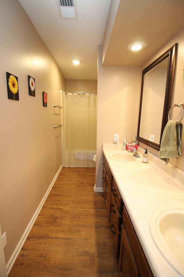 bathroom with toilet, curtained shower, hardwood / wood-style flooring, and vanity