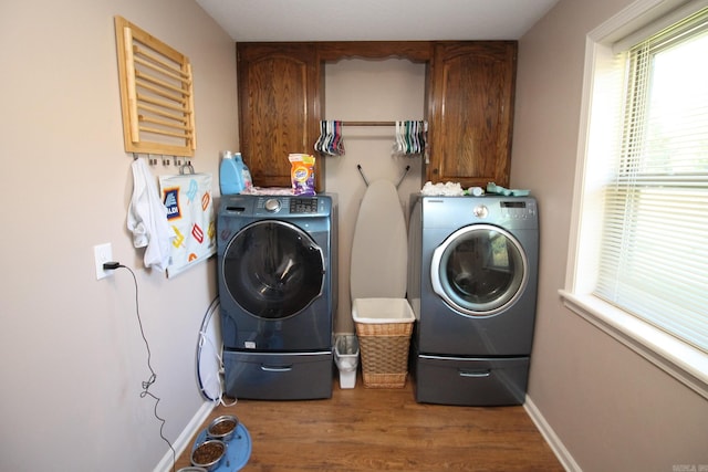 laundry room with cabinets, hardwood / wood-style flooring, and separate washer and dryer