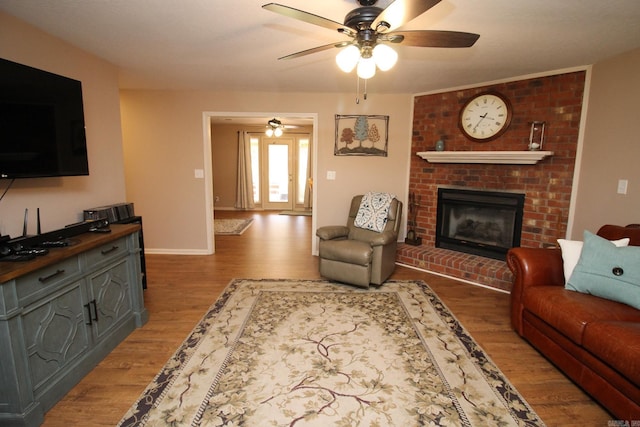 living room featuring a fireplace, hardwood / wood-style flooring, and ceiling fan