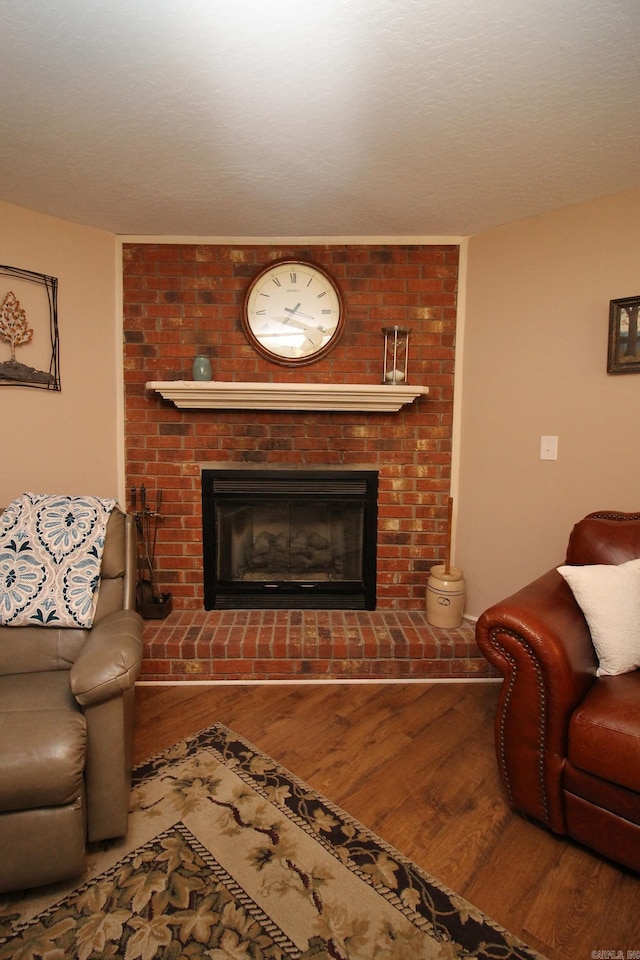 living room with wood-type flooring and a brick fireplace