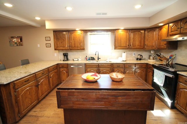 kitchen with a center island, stainless steel dishwasher, light wood-type flooring, and electric range oven