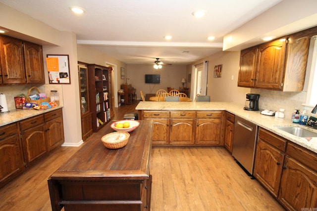 kitchen with light hardwood / wood-style flooring, kitchen peninsula, sink, stainless steel dishwasher, and ceiling fan