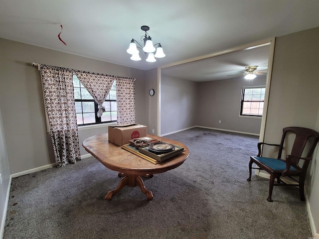 sitting room featuring dark colored carpet, ceiling fan with notable chandelier, and a wealth of natural light