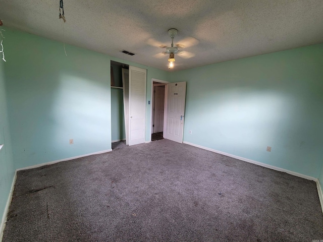 unfurnished bedroom featuring a closet, carpet, a textured ceiling, baseboards, and visible vents