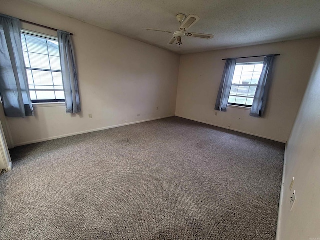 carpeted empty room featuring a textured ceiling, baseboards, and a ceiling fan