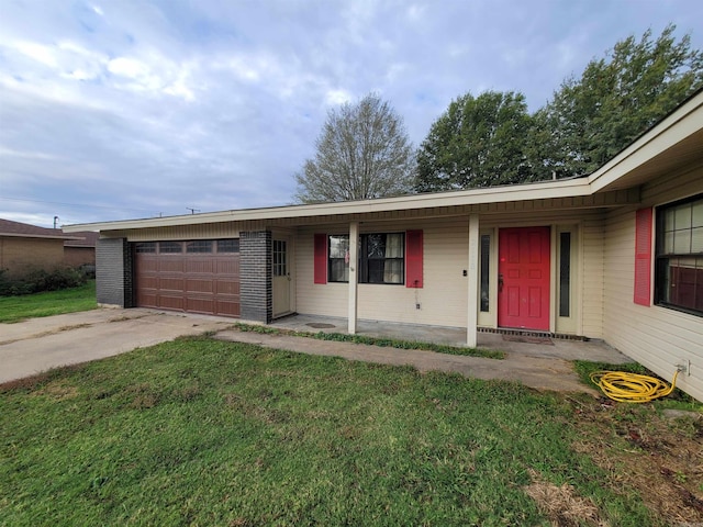 ranch-style house featuring covered porch, a garage, and a front lawn