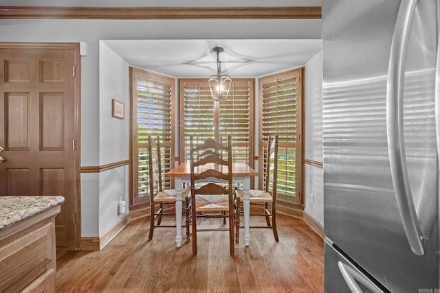 unfurnished dining area featuring light hardwood / wood-style flooring, a chandelier, and a wealth of natural light