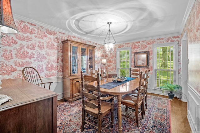 dining room with a notable chandelier, hardwood / wood-style flooring, and ornamental molding