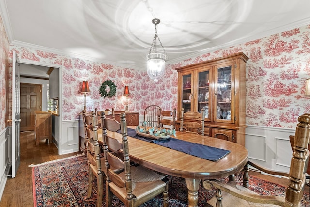 dining room featuring crown molding, dark hardwood / wood-style flooring, and an inviting chandelier