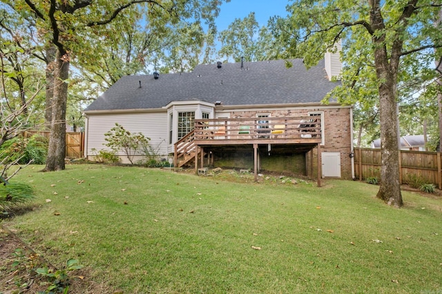 rear view of house with a yard and a wooden deck