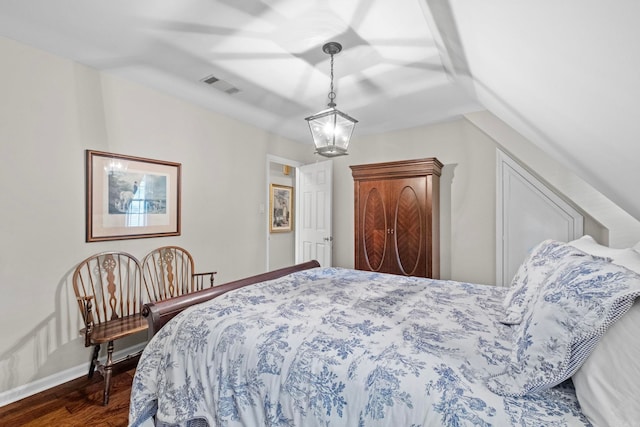 bedroom featuring lofted ceiling, dark hardwood / wood-style flooring, and ceiling fan with notable chandelier