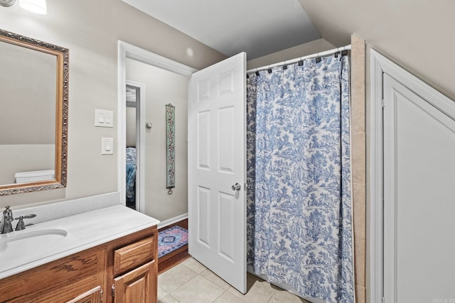 bathroom featuring vanity, vaulted ceiling, and tile patterned floors