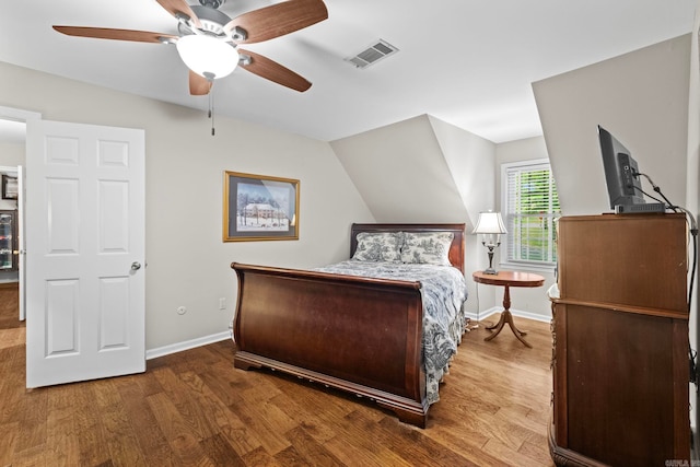 bedroom with hardwood / wood-style floors, vaulted ceiling, and ceiling fan