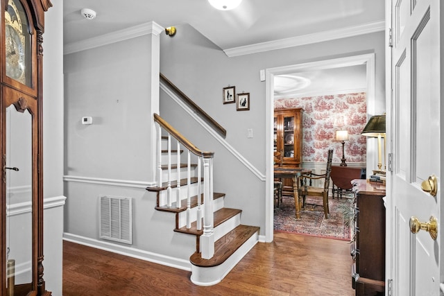 staircase featuring ornamental molding and hardwood / wood-style floors