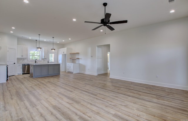 unfurnished living room featuring sink, light hardwood / wood-style floors, and ceiling fan