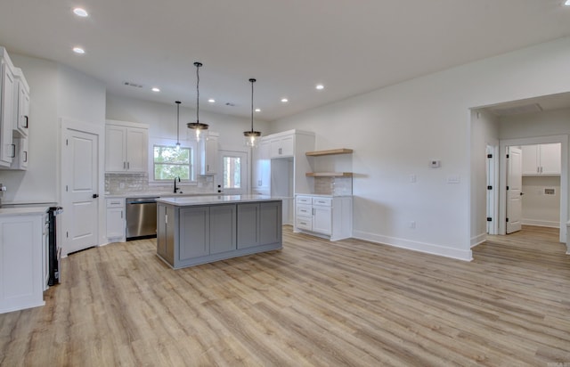 kitchen with white cabinetry, light wood-type flooring, dishwasher, a center island, and electric range oven