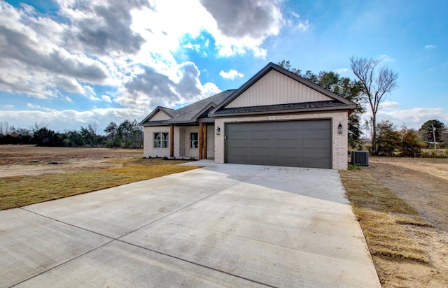 view of front of house featuring a front yard, a garage, and central air condition unit