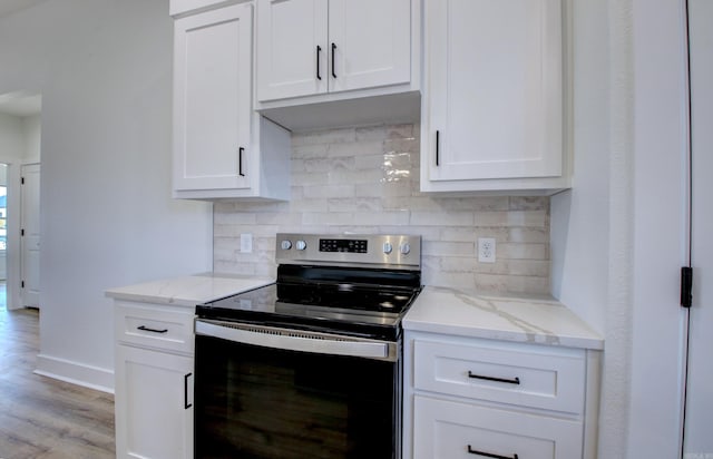 kitchen featuring stainless steel range with electric stovetop, light hardwood / wood-style flooring, and white cabinets