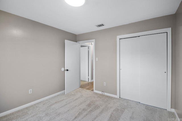 unfurnished bedroom featuring light colored carpet and a closet