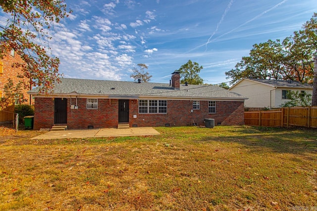 rear view of property featuring a patio and a yard