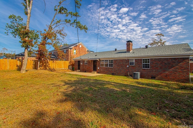 rear view of property featuring a patio area, central AC, and a lawn