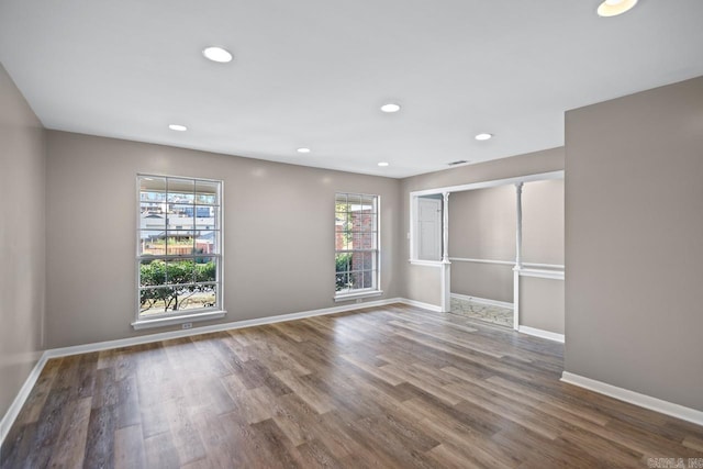 spare room featuring wood-type flooring and a healthy amount of sunlight