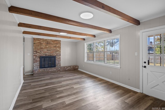 unfurnished living room with a healthy amount of sunlight, beamed ceiling, a brick fireplace, and dark hardwood / wood-style floors