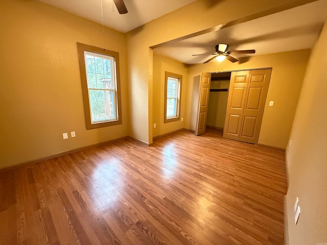 unfurnished bedroom featuring light hardwood / wood-style flooring, ceiling fan, and a closet