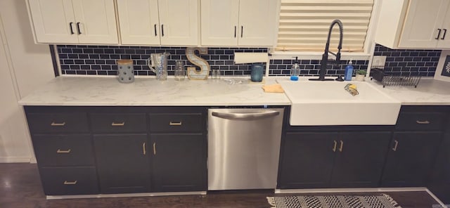 kitchen with decorative backsplash, dishwasher, sink, and light stone counters