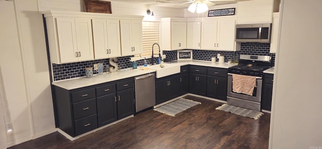 kitchen featuring sink, white cabinets, dark hardwood / wood-style flooring, appliances with stainless steel finishes, and tasteful backsplash