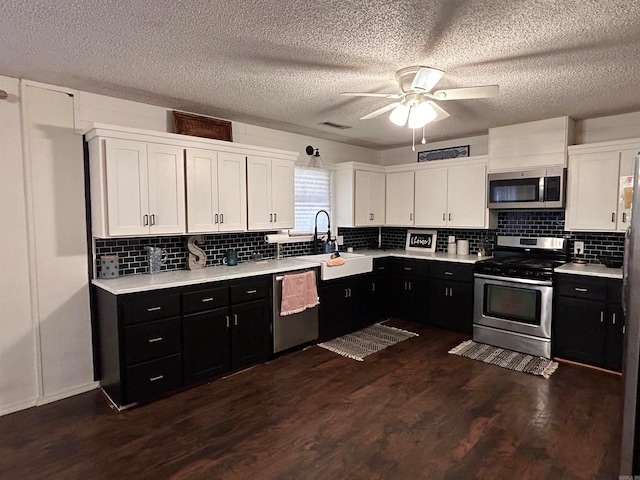 kitchen with sink, stainless steel appliances, white cabinets, decorative backsplash, and dark hardwood / wood-style floors