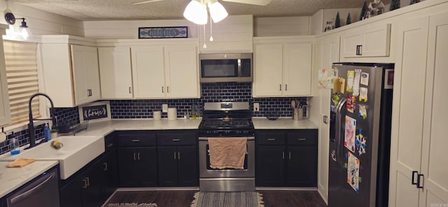 kitchen with sink, backsplash, dark hardwood / wood-style flooring, stainless steel appliances, and white cabinets