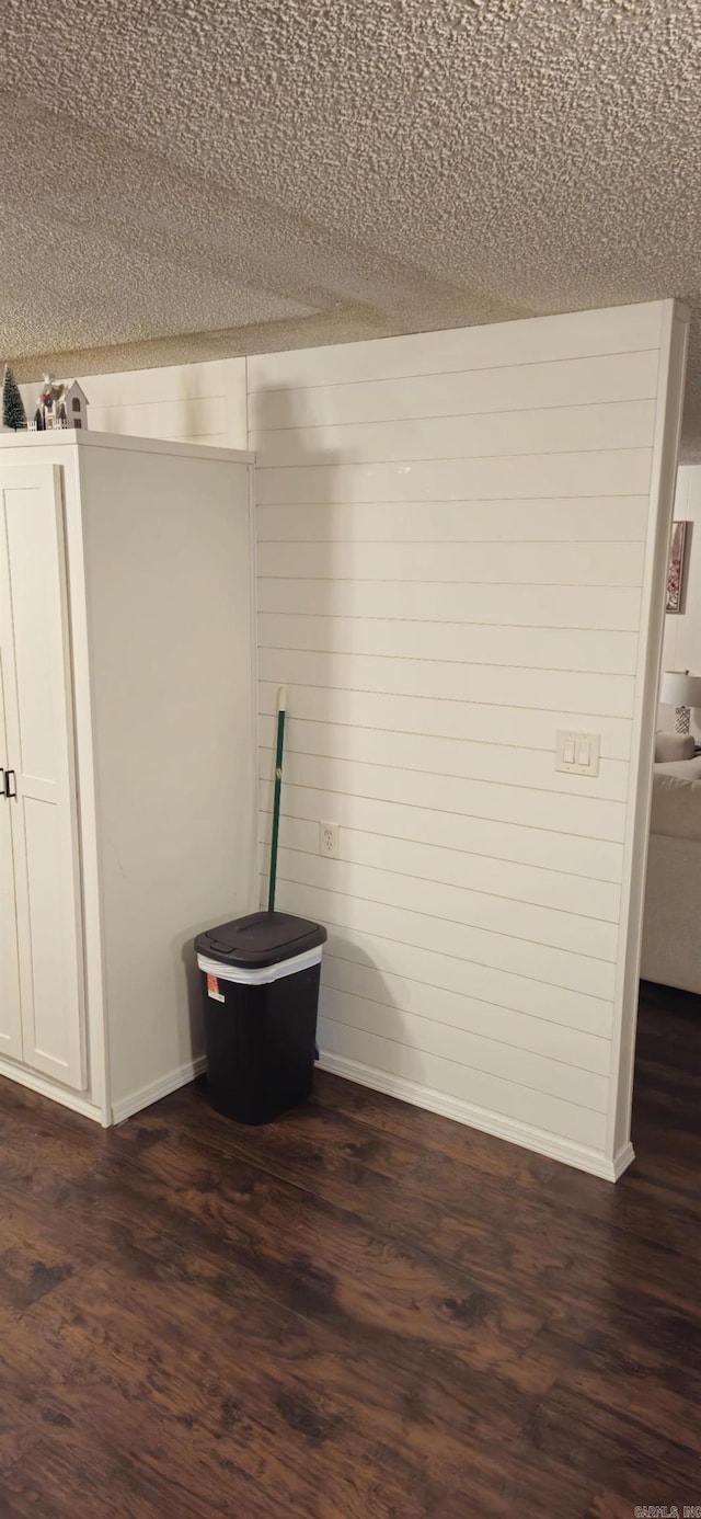 room details featuring hardwood / wood-style floors, a textured ceiling, and wooden walls