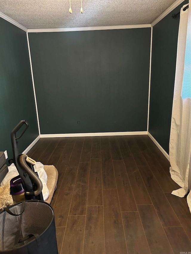 empty room with dark wood-type flooring, crown molding, and a textured ceiling