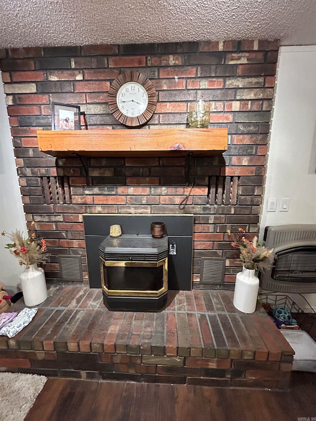 details with heating unit, a textured ceiling, and wood-type flooring