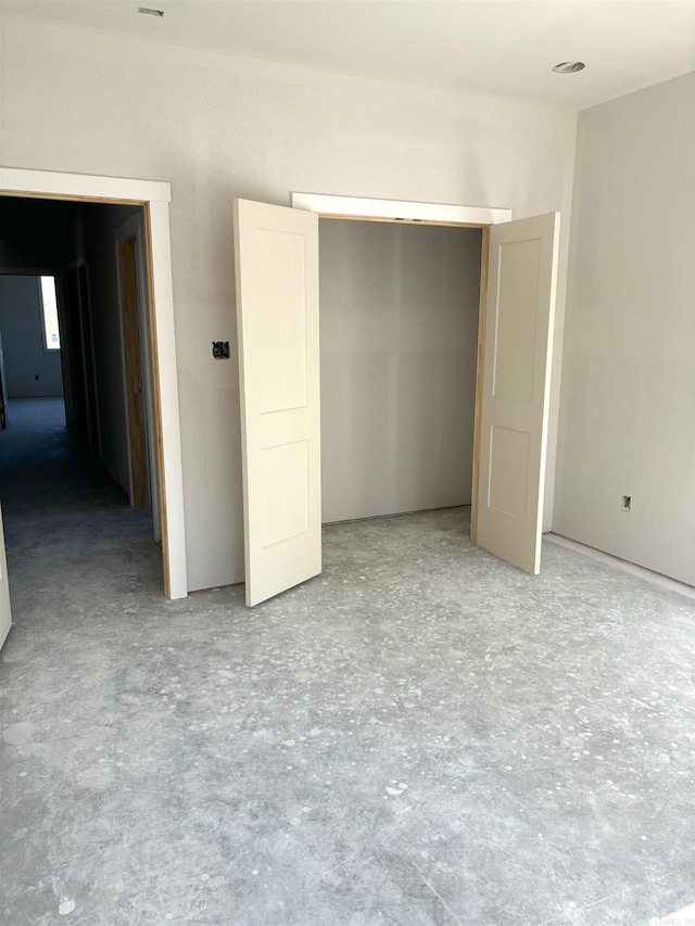 unfurnished bedroom featuring concrete flooring