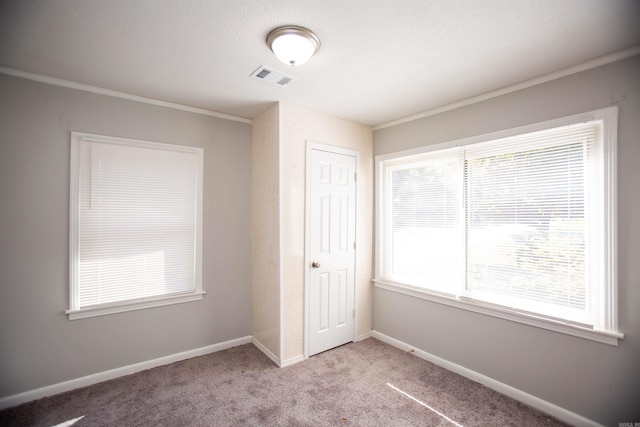 unfurnished bedroom featuring crown molding, multiple windows, a closet, and carpet flooring