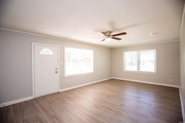 entryway featuring ornamental molding, dark wood-type flooring, plenty of natural light, and ceiling fan