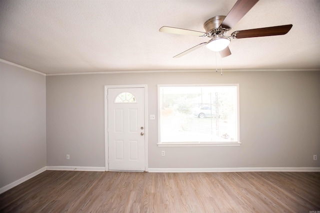 foyer with ornamental molding, hardwood / wood-style flooring, a textured ceiling, and ceiling fan