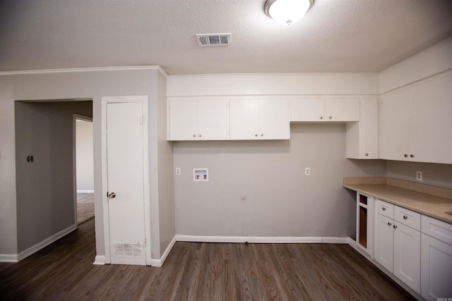 kitchen with crown molding, white cabinetry, a textured ceiling, and dark wood-type flooring