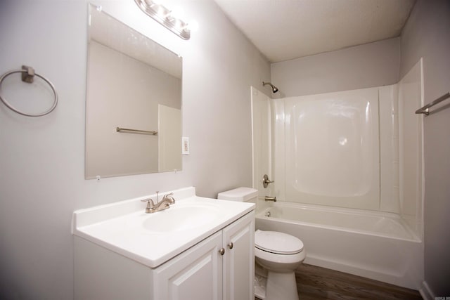 full bathroom with hardwood / wood-style flooring, toilet, vanity, washtub / shower combination, and a textured ceiling