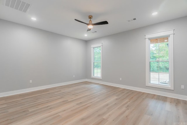 spare room featuring light wood-type flooring, a healthy amount of sunlight, and ceiling fan