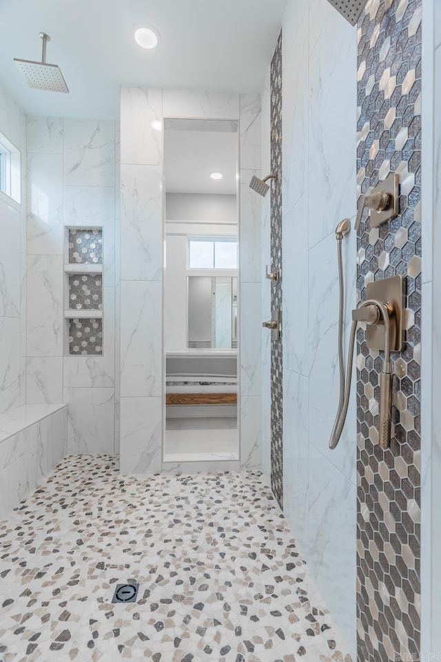 bathroom with a healthy amount of sunlight and a tile shower