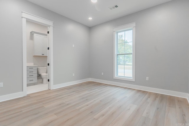 unfurnished bedroom featuring light hardwood / wood-style floors and connected bathroom