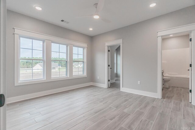 unfurnished bedroom with connected bathroom, light wood-type flooring, and ceiling fan