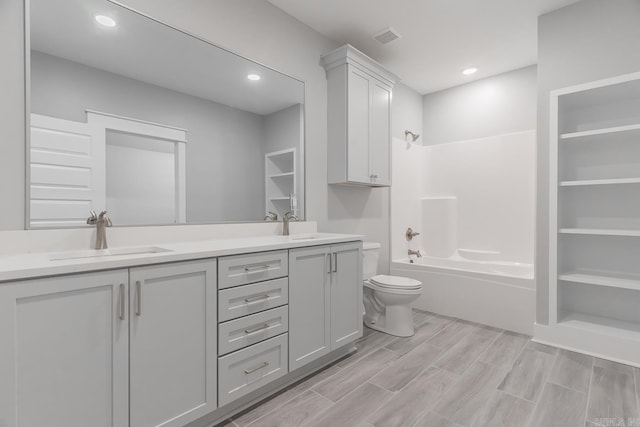 full bathroom with hardwood / wood-style floors, shower / bath combination, vanity, and toilet