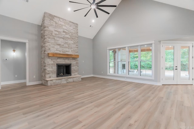 unfurnished living room featuring high vaulted ceiling, a fireplace, ceiling fan, and light hardwood / wood-style flooring