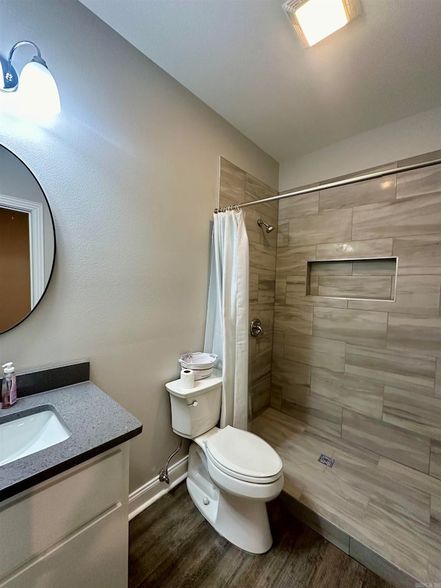 bathroom featuring walk in shower, hardwood / wood-style floors, vanity, and toilet