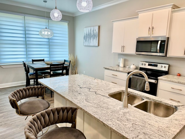 kitchen with white cabinets, decorative light fixtures, crown molding, and stainless steel appliances